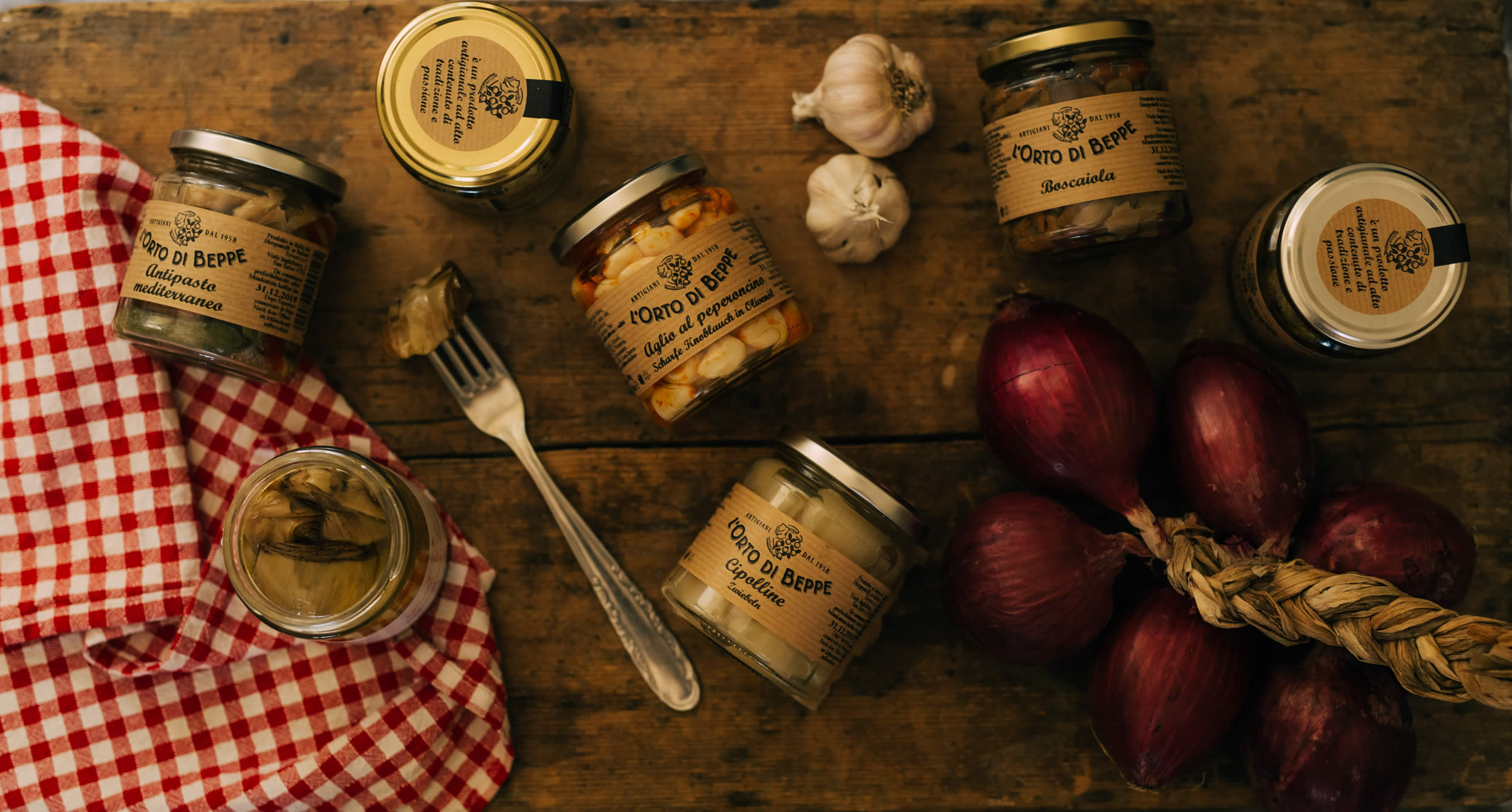 L’Orto di Beppe preserves arranged with fresh ingredients on a table