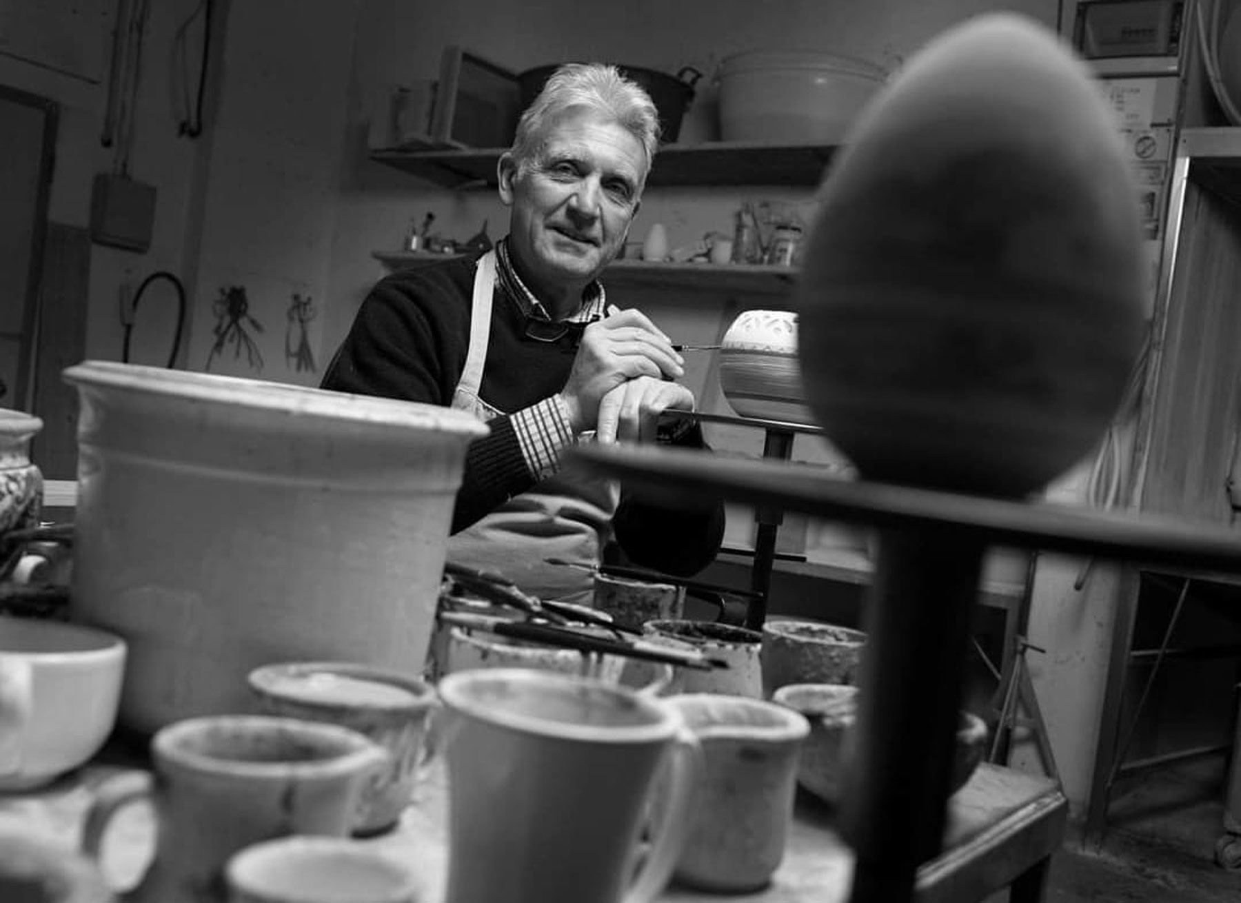 Giuseppe Mercante among ceramic vessels and tools in his workshop in Castelli